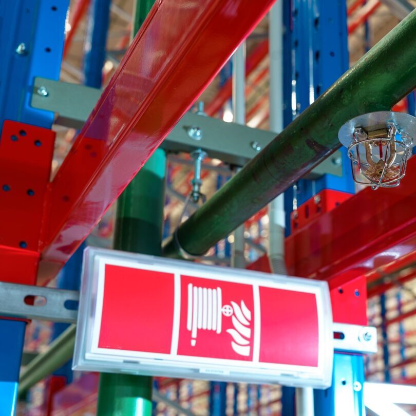 Fire sprinkler in a large warehouse with metal shelving